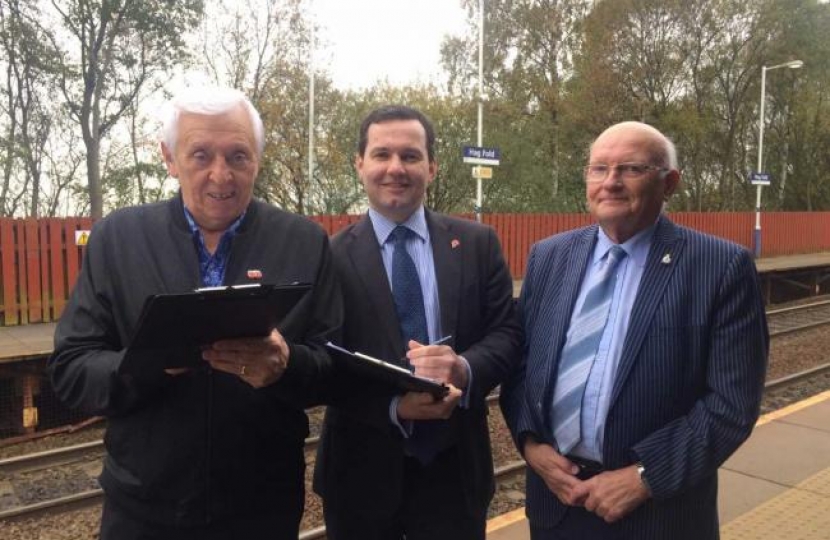 Bolton West MP Chris Green, centre, with a resident signing the petition and chair of The Bridge at Dorset Road Community Centre Norman Bradbury at Hagfold railway station
